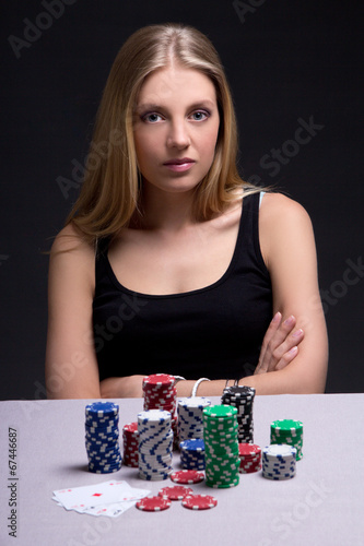 serious woman in casino with cards and chips