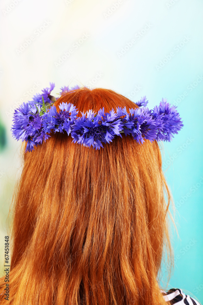 Naklejka premium Fresh cornflower wreath on female head on light background