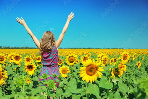 Fototapeta Naklejka Na Ścianę i Meble -  Young woman in sunflower field