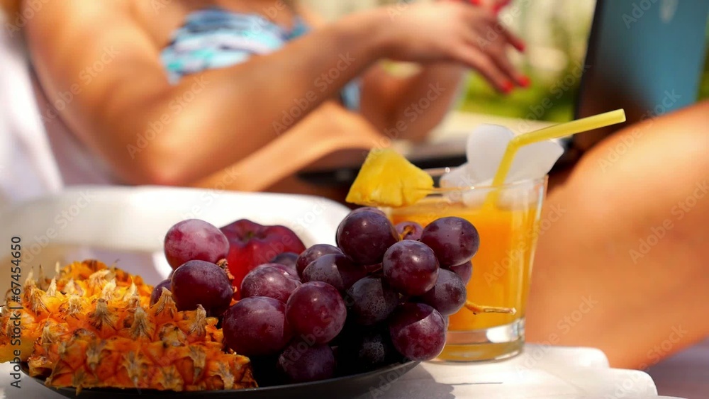 Woman in Bikini Working on Laptop Computer at Poolside. Fruit Woman in Bikini Working on Laptop Computer at Poolside. Fruit