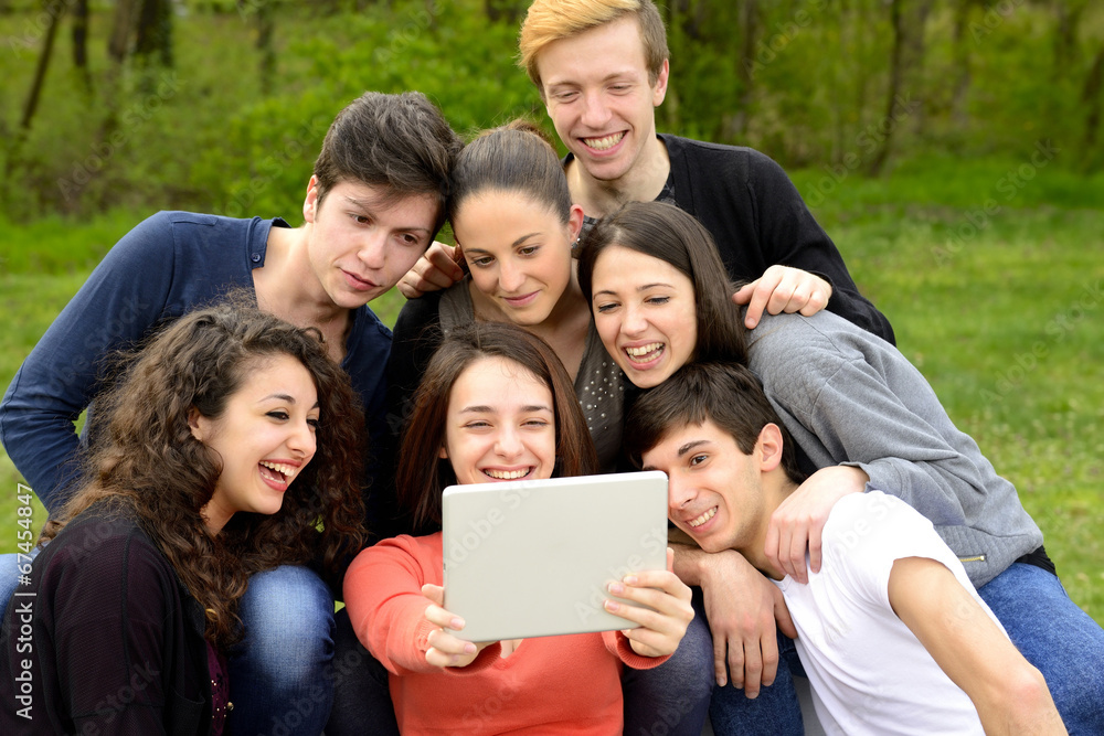 Group of young adults browsing a tablet Group of young adults browsing a tablet