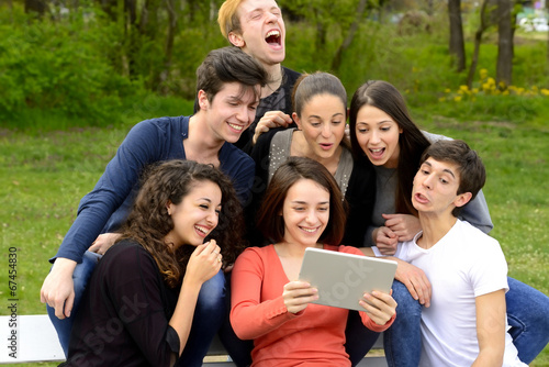 Group of young adults browsing a tablet outside