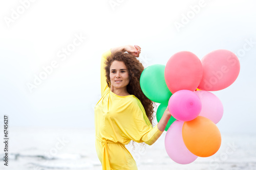 Красивая брюнетка с воздушными шарами в желтом платье