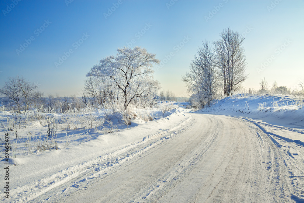 winter landscape with the road, forest and the blue sky