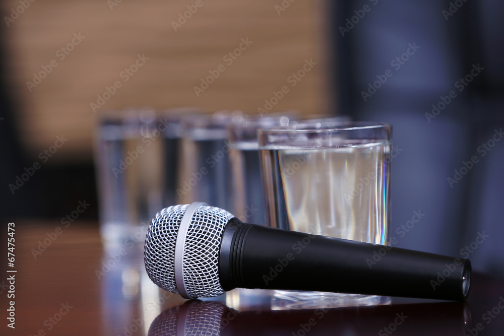 Obraz premium Microphone with glasses of water on table close-up