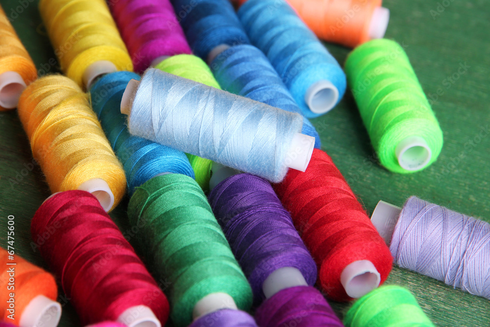 Multicolor sewing threads on wooden background Multicolor sewing threads on wooden background