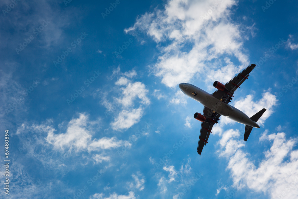 Dark silhouette of an airplane flying over the blue skies Dark silhouette of an airplane flying over the blue skies