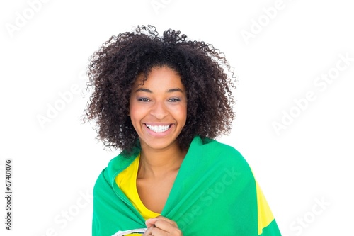 Fotografia Pretty girl in yellow tshirt holding brazilian flag smiling at c