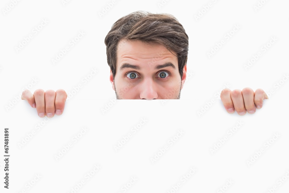 Attractive young man smiling and holding poster Attractive young man smiling and holding poster