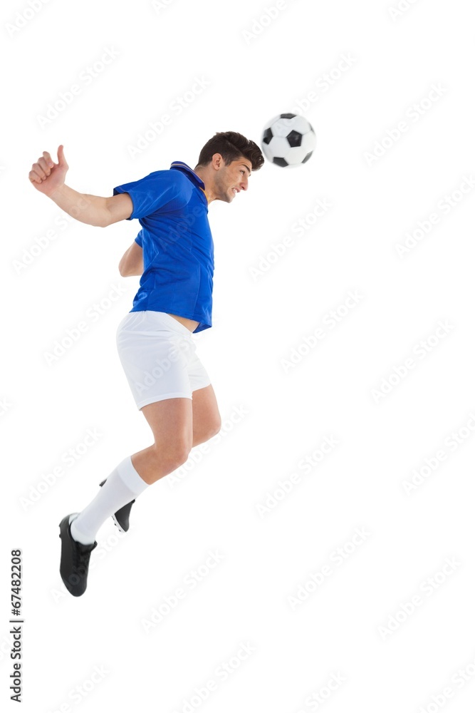 Fototapeta premium Football player in blue jersey heading ball