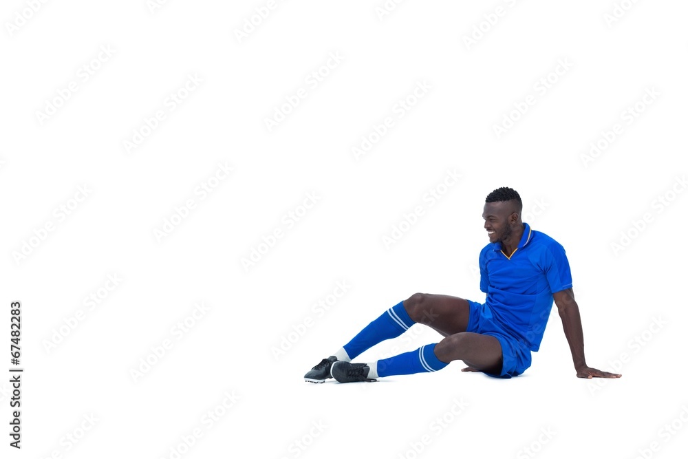 Football player in blue sitting and smiling