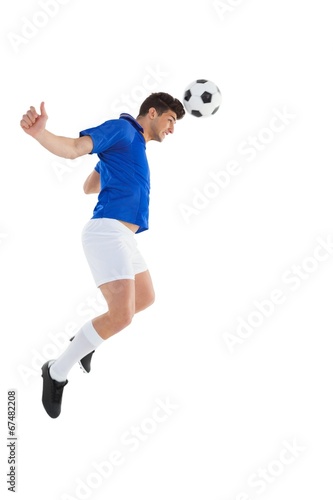 Football player in blue jersey heading ball © WavebreakmediaMicro