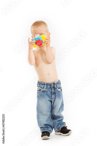 Young half naked boy is taking a photo with his toy camera