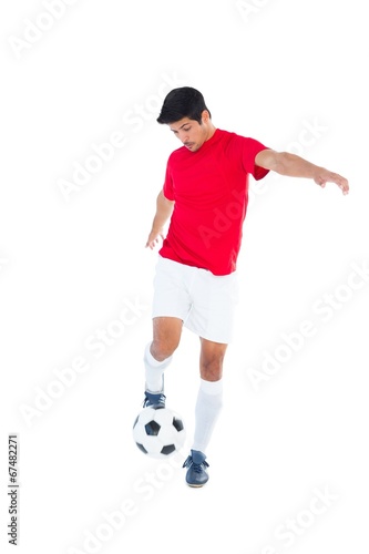 Fototapeta Naklejka Na Ścianę i Meble -  Football player in red kicking ball