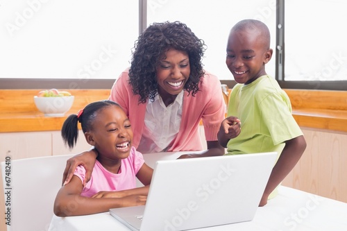 Cute siblings using laptop together with mother © WavebreakMediaMicro