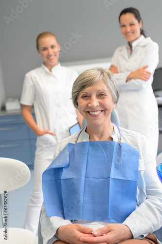 Senior woman patient with professional dentist team