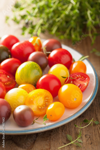 colorful tomatoes in plate on wooden background