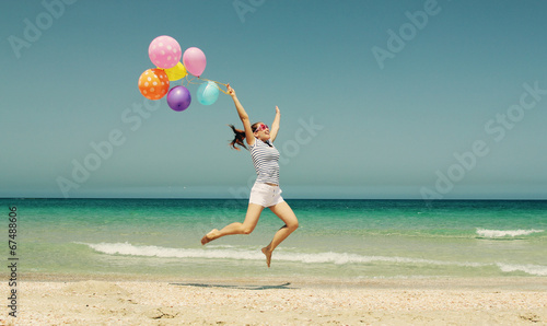 beautiful woman with colorful balloons on seaside