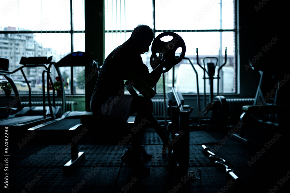 silhouette of an athletic man working out at gym silhouette of an athletic man working out at gym
