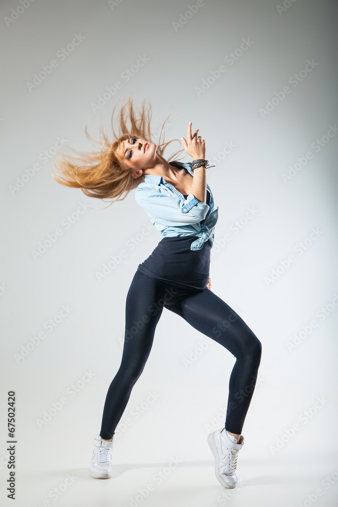 Modern dancer poses in front of studio background