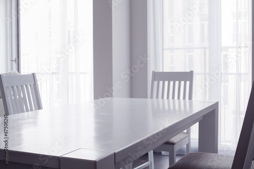 Interior of white kitchen with table