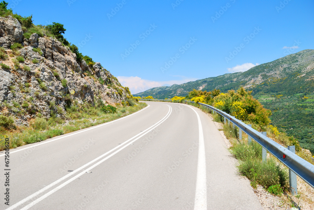 Empty asphalt road in the green hills with blue sky
