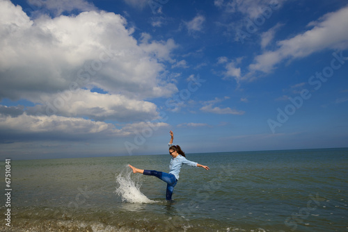 Young woman playing in the sea on a sunny summer day