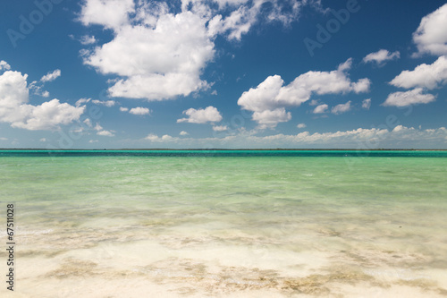 blue sea or ocean, white sand and sky with clouds