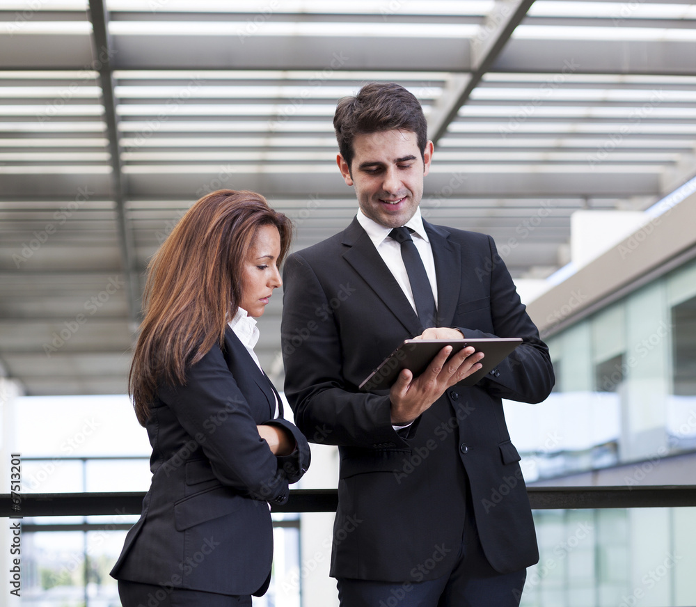 Business people working with electronic tablet at modern office Business people working with electronic tablet at modern office