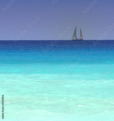 sailboat with a white sail  blue Mediterranean sea