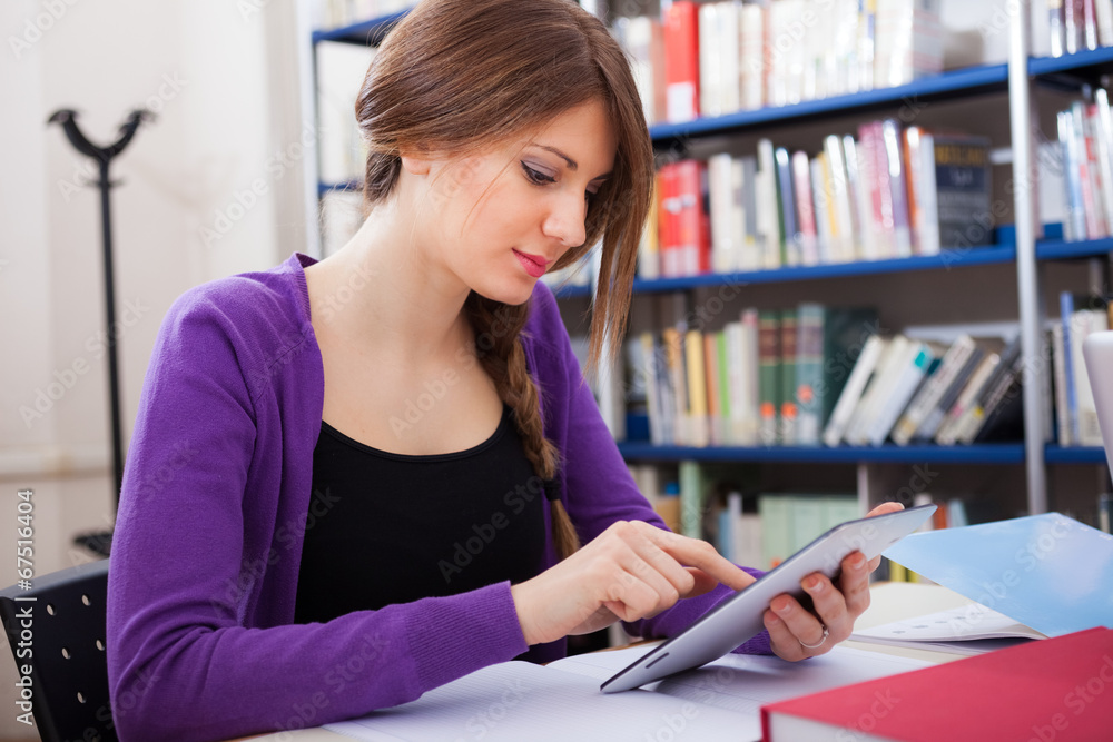 Female student reading a book in library Female student reading a book in library