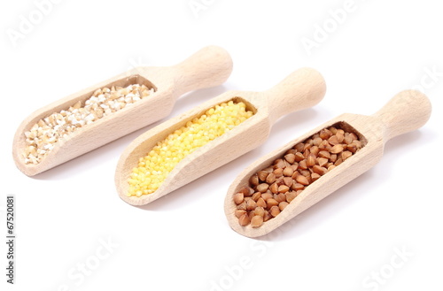 Buckwheat, millet and barley groats with wooden spoon.