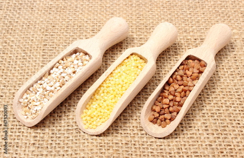 Buckwheat, millet and barley groats on wooden spoon
