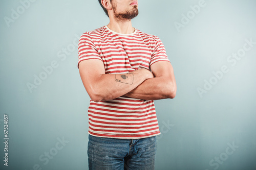 Photos Man in striped shirt with arms crossed