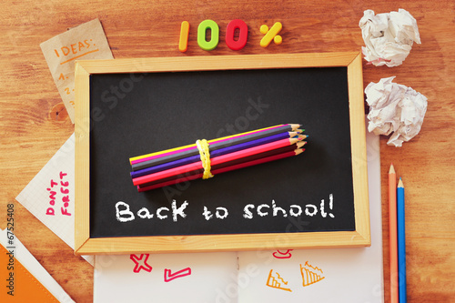 top view of blackboard with the phrase back to school, stack of 