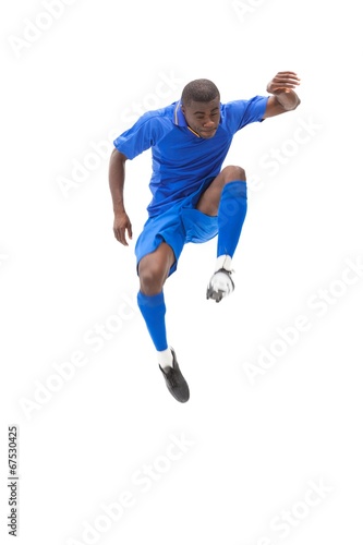 Football player in blue kicking and jumping © WavebreakmediaMicro