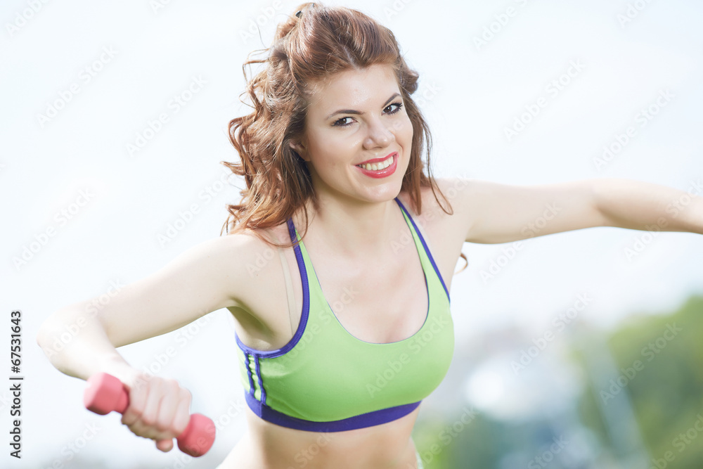 woman with dumbbells in the park woman with dumbbells in the park