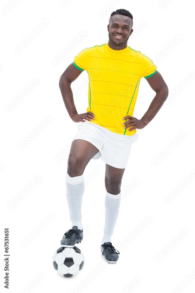 Football player in yellow standing with the ball