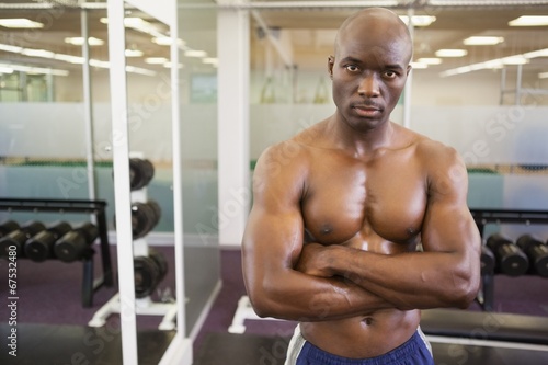 Serious shirtless muscular man in gym