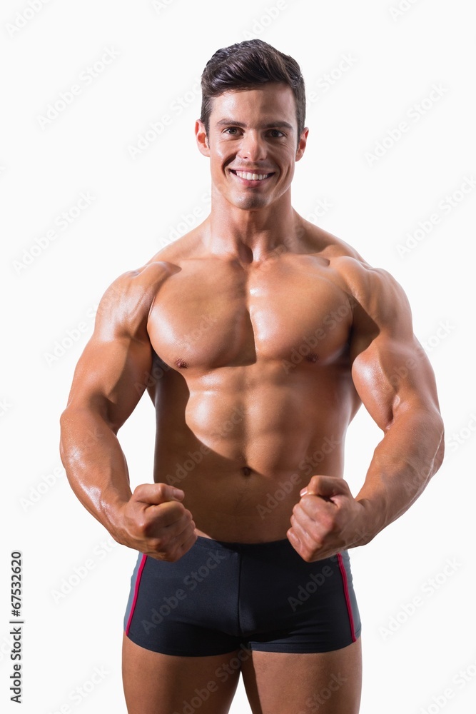 Portrait of a muscular young man clenching fists