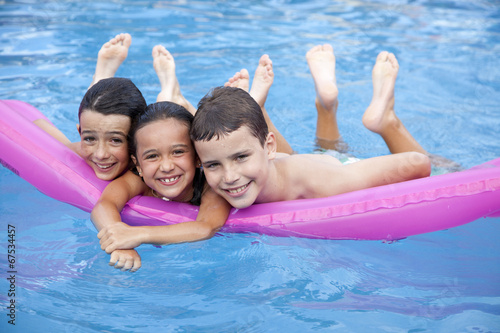 Niños en la piscina sobre colchoneta fucsia