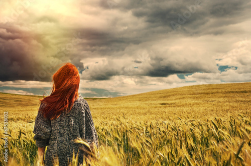 fashion young red hair woman standing back outdoor on breathtaki