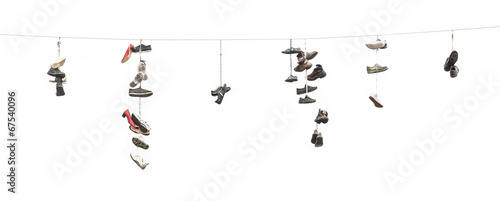 Old worn boots or shoes hang on a cable