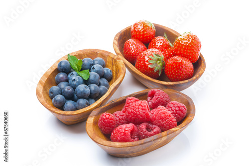raspberries  blueberries and strawberries in a wooden bowls