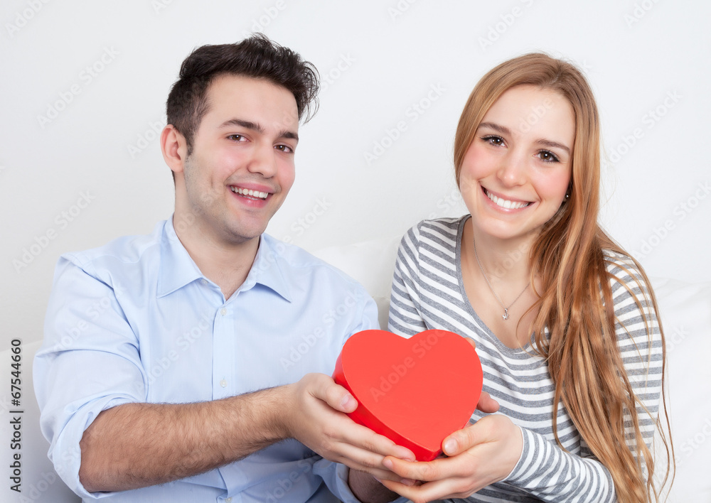 Laughing young love couple with a gift