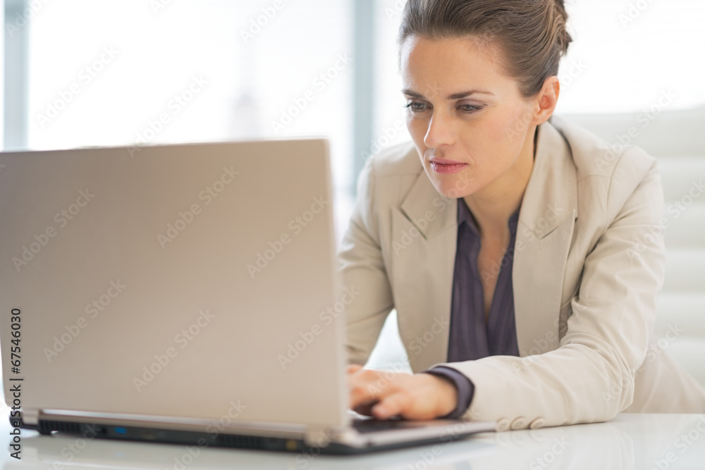 Business woman working on laptop in office Business woman working on laptop in office