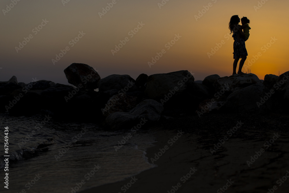 Mother and daughter at the beach at sunset