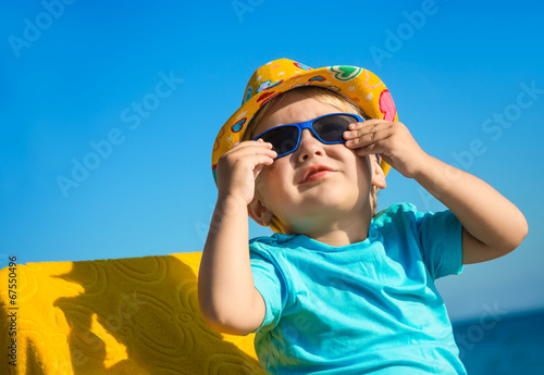Boy kid in sun glasses and hat on beach