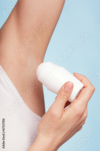 Girl applying stick deodorant in armpit. Skin care