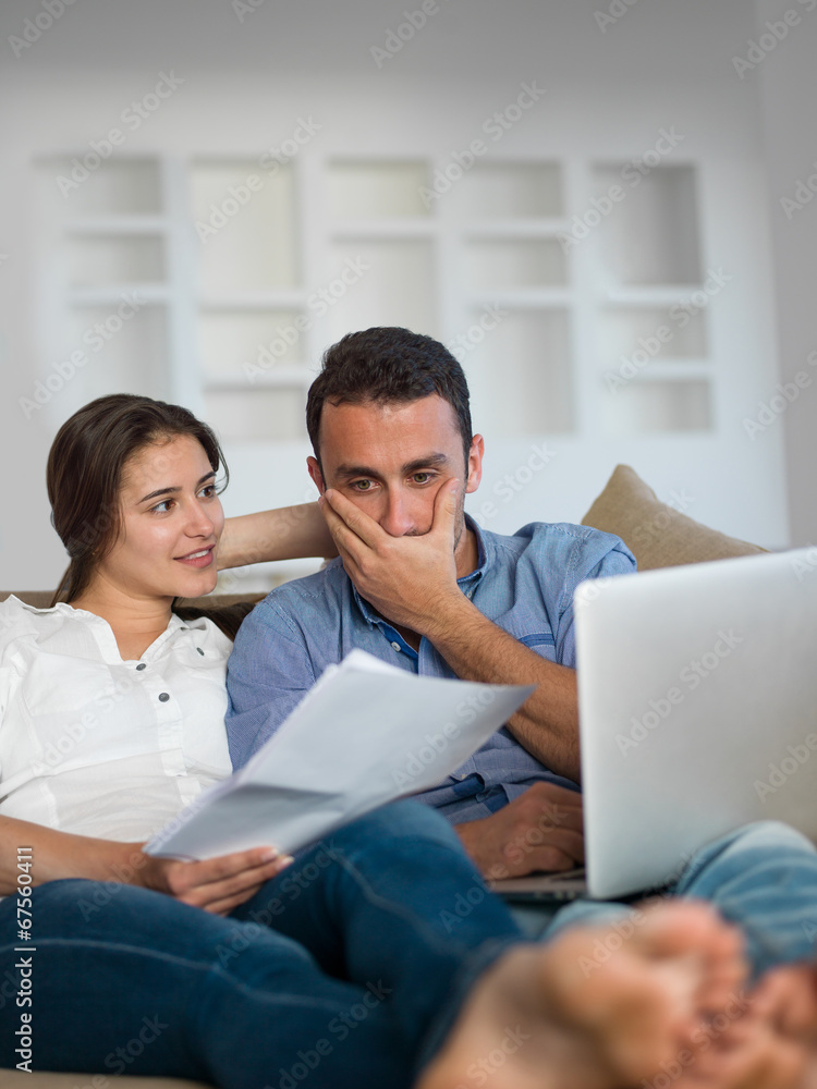 relaxed young couple working on laptop computer at home relaxed young couple working on laptop computer at home